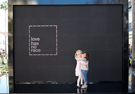 children hugging in front of love has no race sign