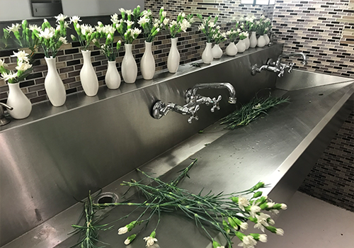 prepping for live event - filling flower vases in a bathroom sink