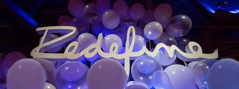 redefine sign covered in balloons